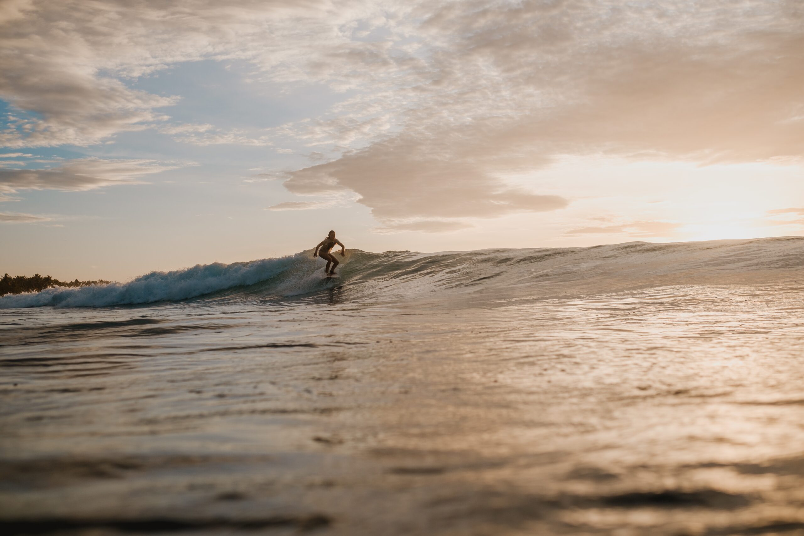 A woman surfing in the Mentawai Islands, Sumatra, Indonesia